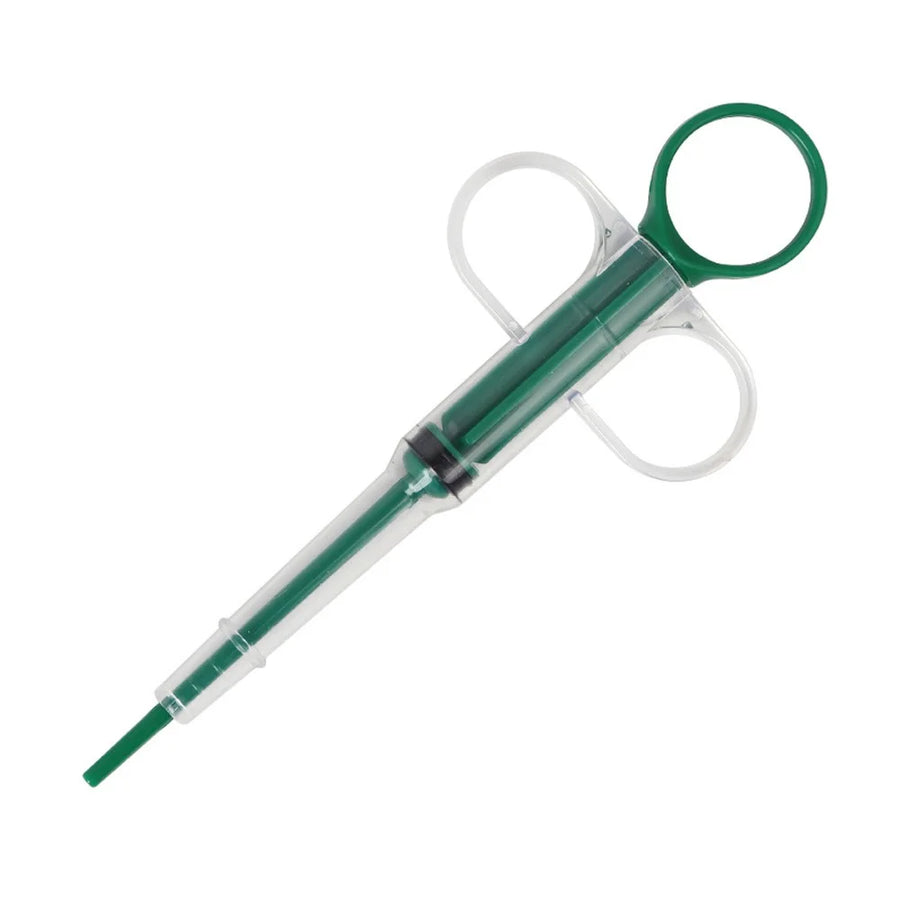 Green pet pill feeder syringe with finger-ring plunger and soft tip on white background – pill dispenser for dogs and cats
