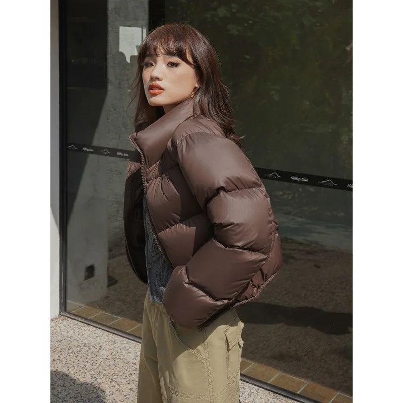 Woman modeling a brown cropped puffer jacket outdoors in winter