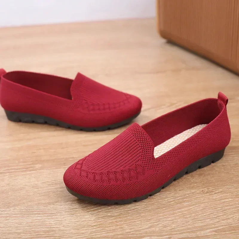 Red loafers on a wooden floor