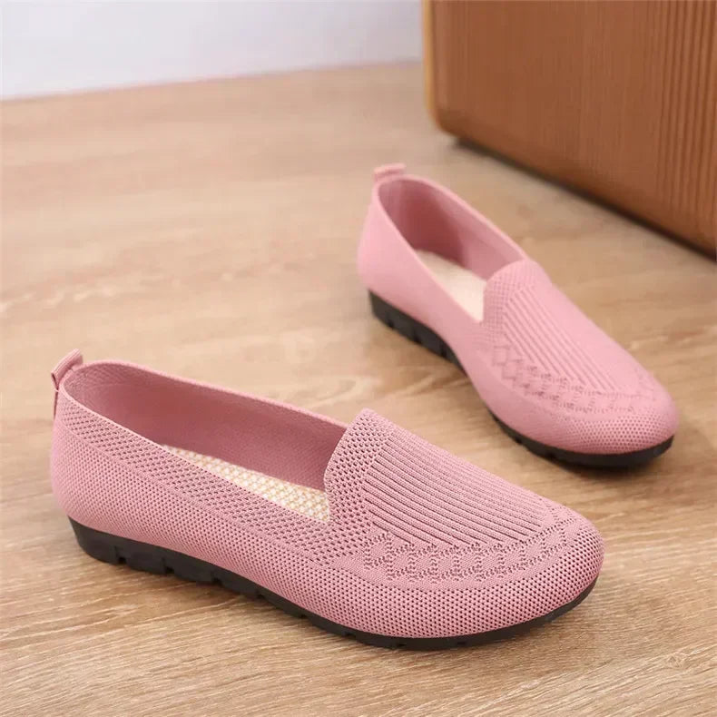 Pair of pink loafers on a wooden floor