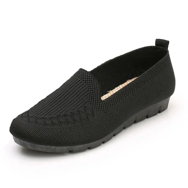 Black slip-on shoe with a white background