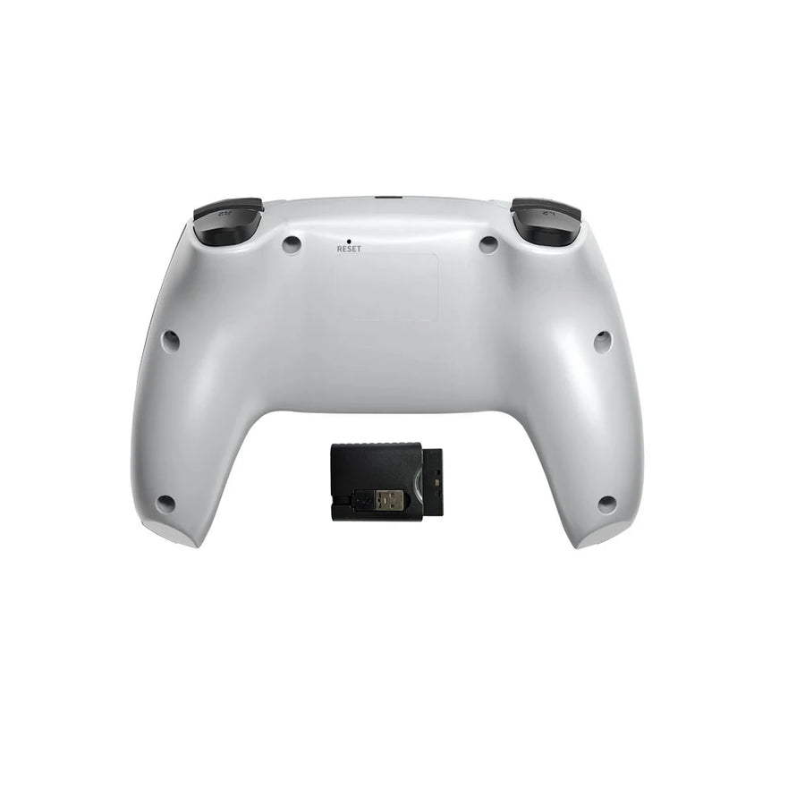 Silver gaming controller with a small black device on a white background