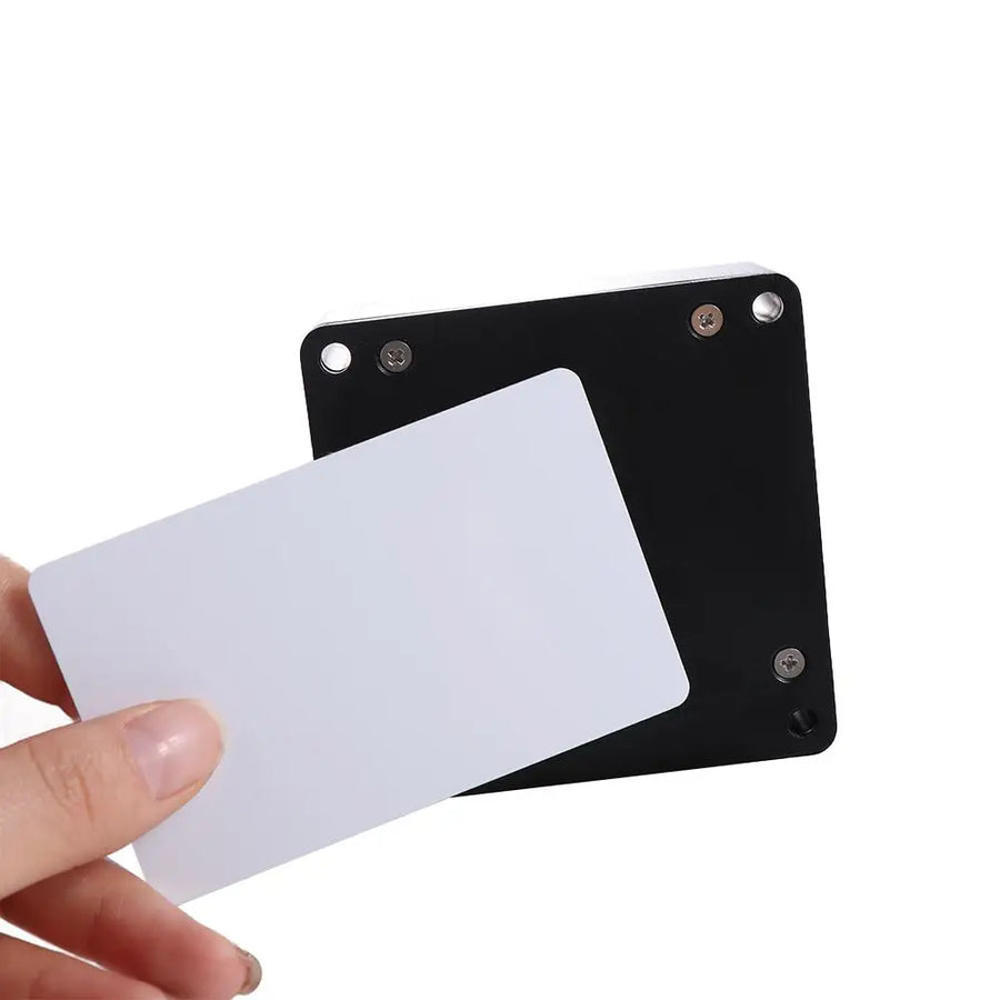 Hand holding white RFID IC card next to black hidden electronic drawer lock plate, keyless cabinet access card