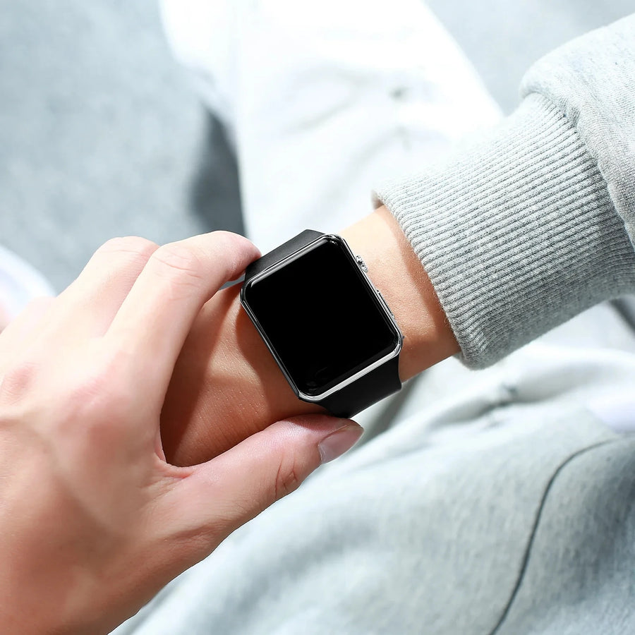 Person wearing a black LED digital sport watch with black screen on wrist, unisex casual digital watch.