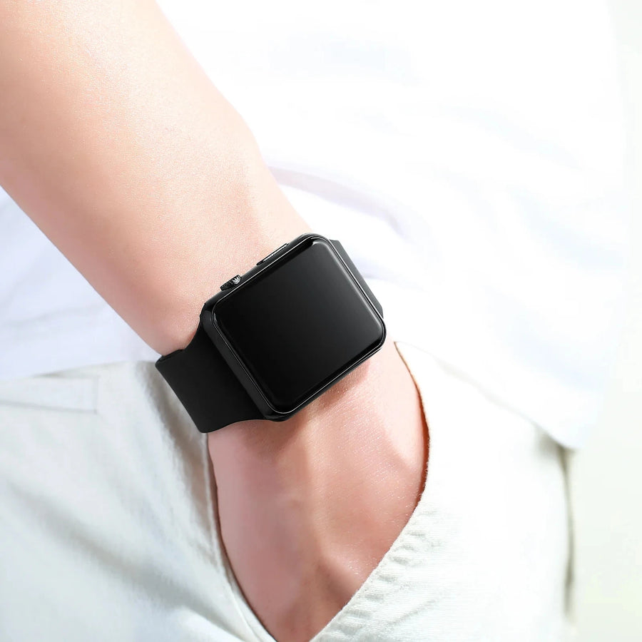 Person wearing a black LED digital sport watch with black screen on wrist, casual unisex digital watch on light background.