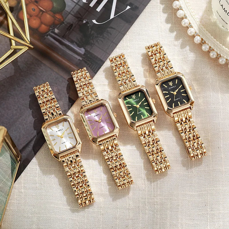 Four women's gold quartz watches with different dial colors on textured surface