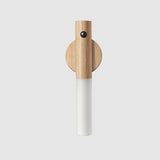 Wooden and white cylindrical object on a light gray background