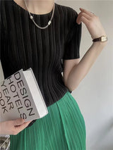 Detail view of O-neck on women's pleated short sleeve top
