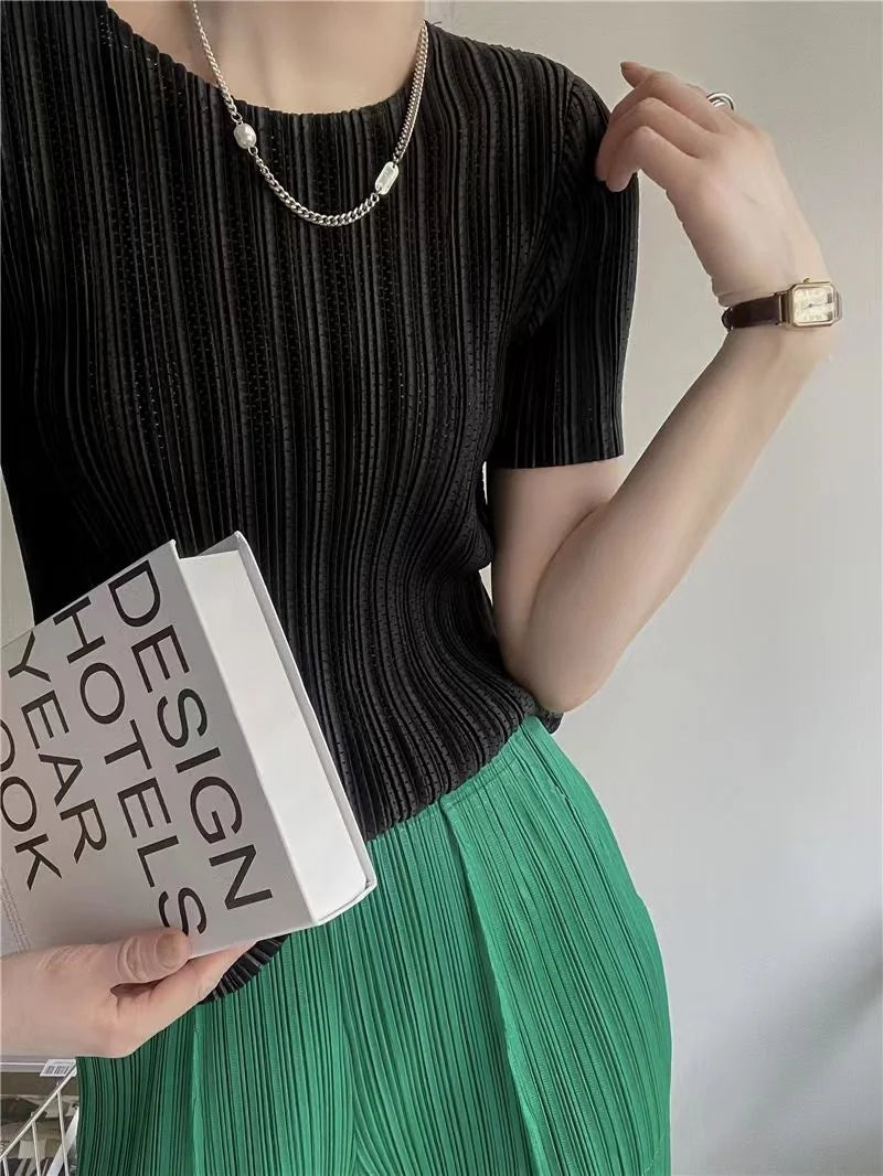 Detail view of O-neck on women's pleated short sleeve top