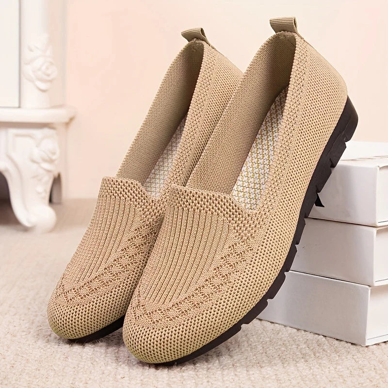 Pair of beige slip-on shoes on a light background