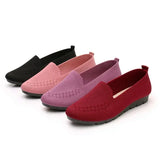 Four pairs of slip-on shoes in black, pink, purple, and red on a white background.