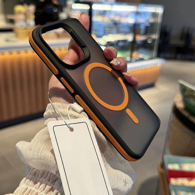 Person holding a phone case with a tag in a blurred indoor setting
