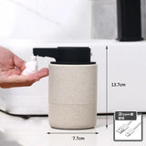 Automatic touchless soap dispenser with infrared sensor – hand holding small soap bottle beside cylindrical dispenser, dimensions shown