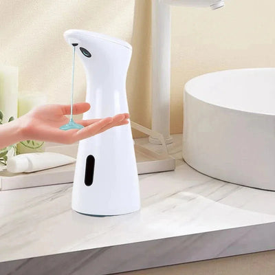 Hand soap dispenser on a bathroom counter with a hand reaching out to dispense soap.