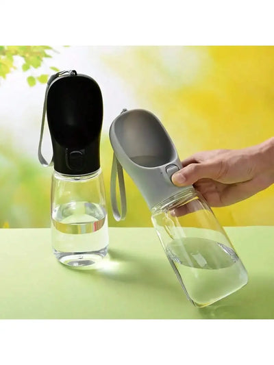 Clear water bottle with black and gray covers on a light green surface.