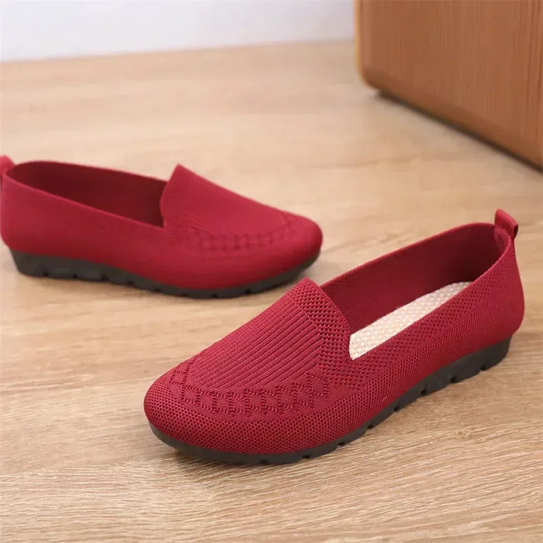 Red loafers on a wooden floor