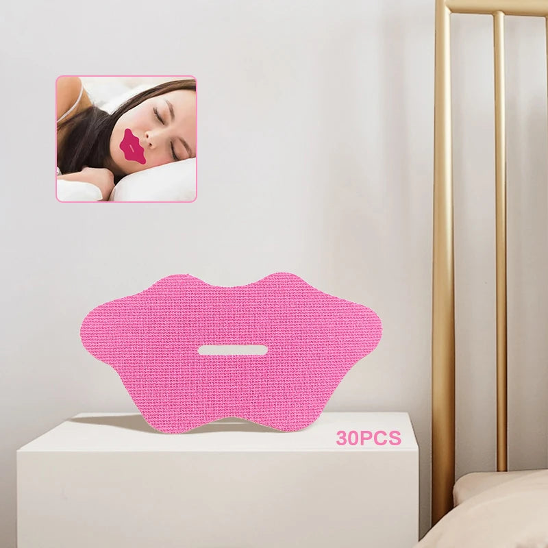 Pink lip-shaped anti-snoring mouth tape strips on white surface with bedroom background