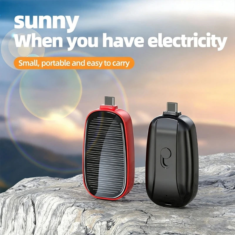 Two portable devices, one red and one black, on a rocky surface with a scenic background.