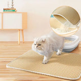 Cat walking on a double-layer honeycomb cat litter trapping mat with a litter box and cat tree in the background