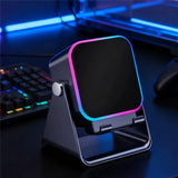 Gaming desk setup with a smartphone stand and colorful keyboard in the background