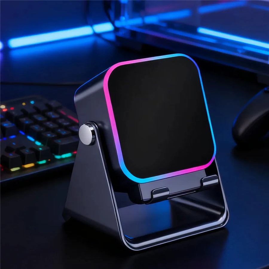 Gaming desk setup with a smartphone stand and colorful keyboard in the background