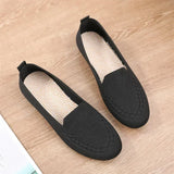 Pair of black slip-on shoes on a wooden surface