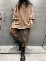 Womens plus size long sleeve top in light coffee, loose fit casual t-shirt with black boots against gray wall