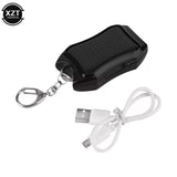 Black solar-powered device with keychain and USB cable on a white background
