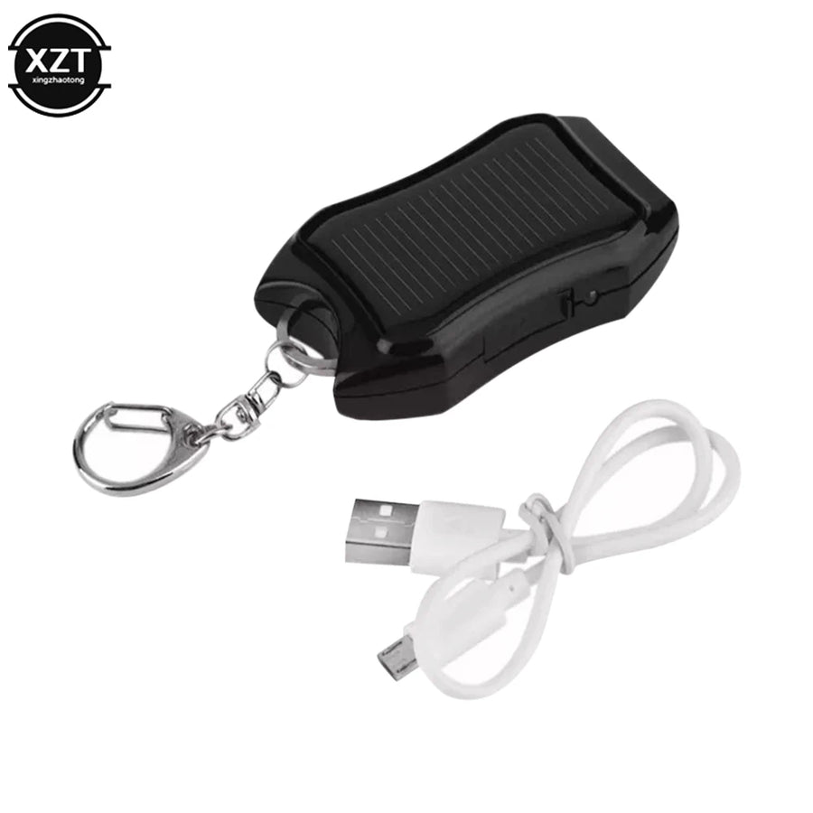 Black solar-powered device with keychain and USB cable on a white background