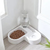 Pet food bowl with water dispenser on a light wood floor.