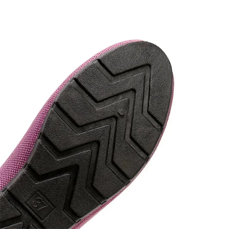 Close-up of a pink shoe sole with black tread pattern on a white background
