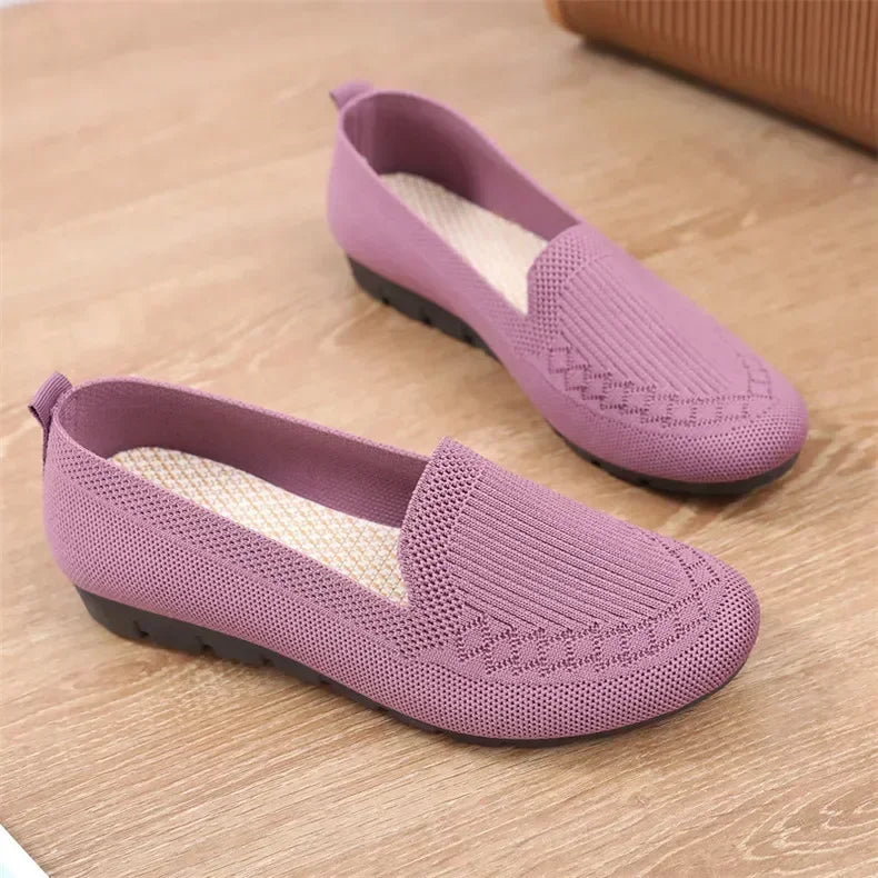 Pair of purple loafers on a wooden floor