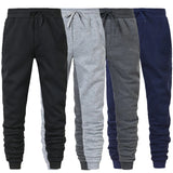 Four pairs of jogger pants in black, gray, and navy on a white background
