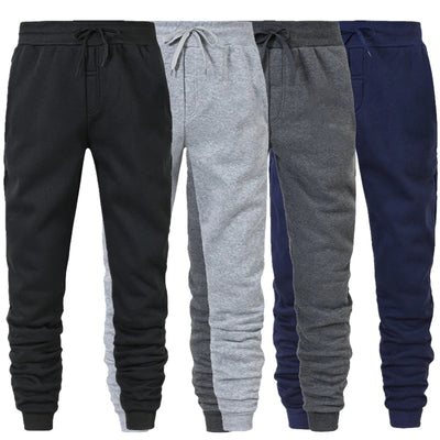 Four pairs of jogger pants in black, gray, and navy on a white background