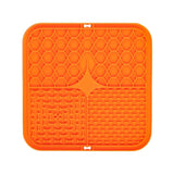 Orange silicone mat with textured surface on a white background