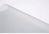 Close-up of a textured gray surface with small yellow particles on a white background
