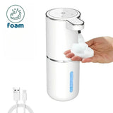 Foam soap dispenser with hand pressing it, USB cable on a white background