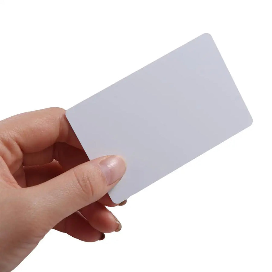 Hand holding blank white RFID IC card for hidden electronic drawer lock, keyless cabinet access card