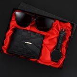 Black sunglasses, wallet, and watch in a box with red interior