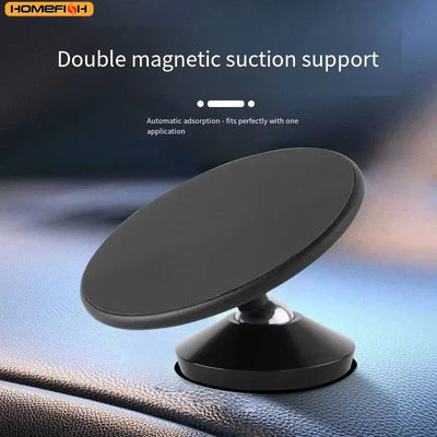 A black magnetic phone mount with a circular suction base, shown attached to a car dashboard. The image includes text overlays reading 'Double magnetic suction support' and 'Automatic adsorption - fits perfectly with one application' with the brand logo 'HOMEFISH' in the top left corner.