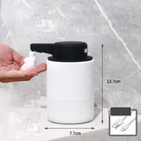 White touchless automatic soap dispenser with infrared motion sensor dispensing foam, marble background