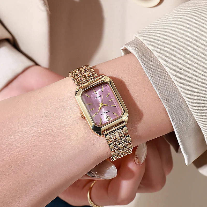 Women's gold quartz watch with pink dial on wrist